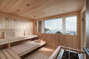 a sauna with wooden paneling and a large window at b-smart hotel Arbon in Arbon