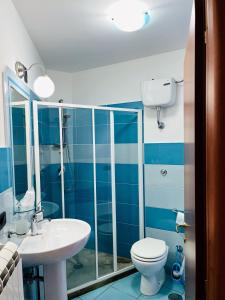 Baño azul con aseo y lavamanos en La Casa al Piccolo Borgo en Vallo della Lucania