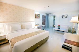 a bedroom with a large bed and a living room at The Cube Malioboro Hotel in Yogyakarta