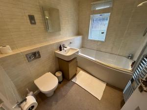 a bathroom with a sink and a tub and a toilet at Cornish Beach Lodge in Torpoint