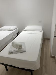- 2 lits avec serviettes dans une chambre dans l'établissement Villa Milano Apt. n. 1, à Milan