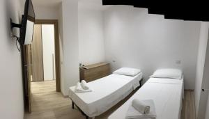 a white room with two beds and a tv at Villa Milano Apt. n. 1 in Milan