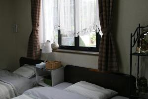 a bedroom with two beds and a window at Private Inn Bambee in Kobe