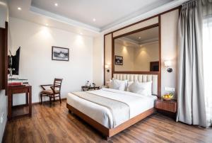 um quarto de hotel com uma cama grande e uma secretária em Amritara Sadka Amritsar em Amritsar