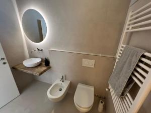 a bathroom with a toilet and a sink and a mirror at Verbano Boutique Apartment in Meina +21 photos