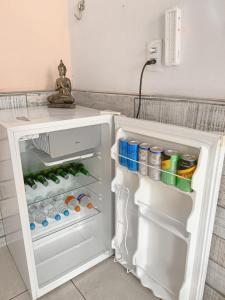 um frigorífico aberto cheio de bebidas e refrigerantes em Suíte no centro histórico em Pirenópolis
