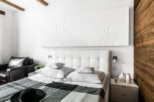 Un dormitorio blanco con una cama y una silla. en Willa Art, en Zakopane