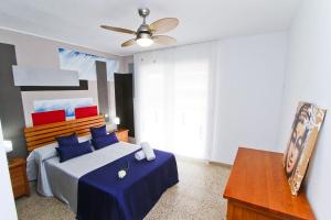 1 dormitorio con 1 cama con sábanas azules y ventilador de techo en New OKSANA PlanetCostaDorada, en Salou