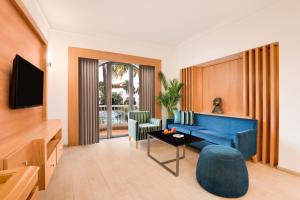 a living room with a blue couch and a table at Lemon Tree Hotel, Aurangabad in Aurangabad