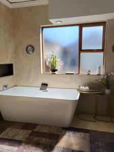 a white bath tub in a bathroom with a window at 17 On Buffalo in Johannesburg