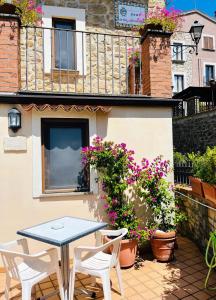 a patio with a table and chairs and flowers at La Casa al Piccolo Borgo in Vallo della Lucania