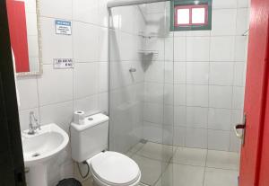 y baño con ducha, aseo y lavamanos. en Suíte no centro histórico, en Pirenópolis