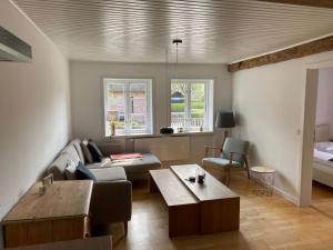 ein Wohnzimmer mit einem Sofa und einem Tisch in der Unterkunft Kurnkoomer in Alkersum