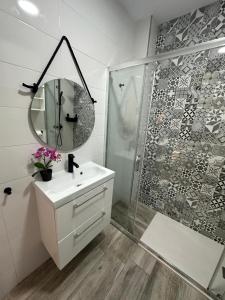 een badkamer met douche, wastafel en spiegel bij Loft Vialia Centro in Málaga +3 foto's