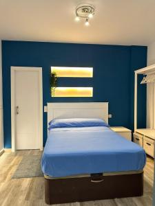 een blauwe slaapkamer met een bed met een blauwe muur bij Loft Vialia Centro in Málaga