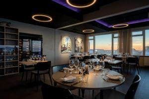 a dining room with tables and chairs and windows at Hotel Hvide Falk in Ilulissat