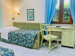 a bedroom with a bed and a desk and a chair at Residence dei Fiori in Campo nell'Elba