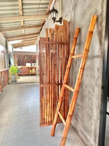 a stack of bamboo leaning against a wall at Lanta Sabai Day House in Ko Lanta