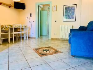 a living room with a blue couch and a tile floor at Residence dei Fiori in Campo nell'Elba