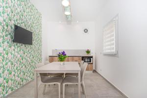 a dining room with a white table and chairs at Coste Ponente Appartamenti Turistici in Ragusa