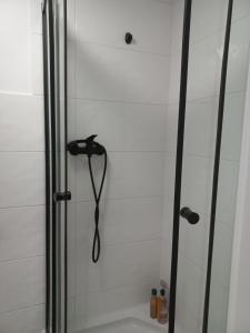 a shower with a black shower head in a bathroom at Przytulne studio przy Atlas Arena i malowniczym parku in Łódź