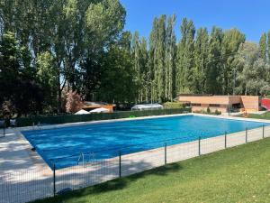 a large blue swimming pool in a yard at Acogedora casa del siglo XIX in Bahabón