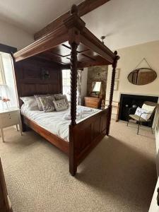 The Corner House Belford في بلفورد: غرفة نوم مع سرير من المظلة الخشبية في غرفة