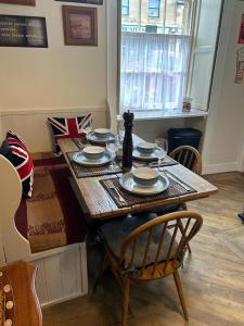 una mesa de comedor con platos y platos. en The Corner House Belford, en Belford