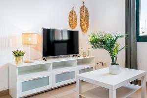 a living room with a tv on a white dresser at Lodging Apartments Liceu G1 in Barcelona