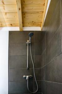 a shower in a bathroom with a wooden ceiling at Casa das Pedras Country Retreat in Santo António das Areias