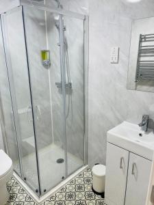 a bathroom with a shower and a toilet and a sink at Riverside Premium Double Room E14 in London