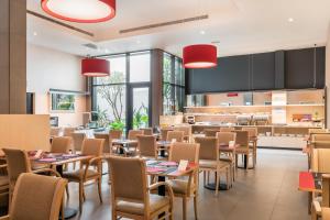 バルセロナにあるサノテル クラブ セントラルのテーブルと椅子のあるレストラン、キッチンが備わります。