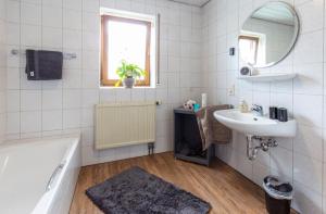a bathroom with a tub and a sink and a mirror at Ferienwohnung Franz Erlabrunn in Erlabrunn