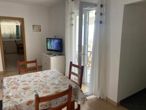 ein Esszimmer mit einem Tisch und einem TV in der Unterkunft Merla in Trogir