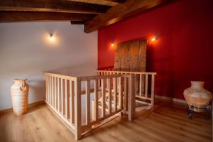 a room with a staircase with a red wall and vases at El Rincón de Antonio in Monfarracinos