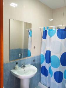a bathroom with a sink and a shower curtain at Banda playa 82, en pleno corazón de Sanlucar in Sanlúcar de Barrameda