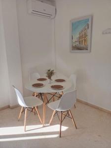 a white table and chairs in a white room at Banda playa 82, en pleno corazón de Sanlucar in Sanlúcar de Barrameda
