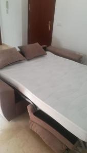 a bed in a room with a white mattress at Banda playa 82, en pleno corazón de Sanlucar in Sanlúcar de Barrameda