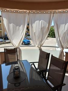 a glass table and chairs with a view of a street at APPLeonLux in Umag