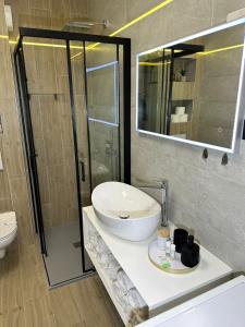 uma casa de banho com um lavatório, um WC e um espelho. em APPLeonLux em Umag
