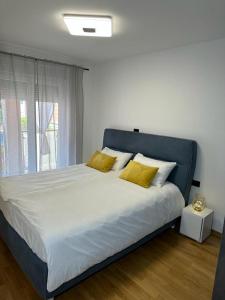 um quarto com uma cama grande e almofadas amarelas em APPLeonLux em Umag