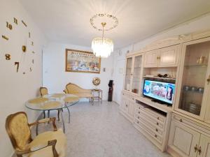 a living room with a table and a tv at Apartamento acogedor con wifi in Valencia