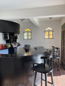 eine Bar in einem Restaurant mit schwarzen Stühlen in der Unterkunft Starlight Chalet & Health Spa in Spa Spring