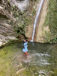 una mujer parada en el agua cerca de una cascada en Starlight Chalet & Health Spa, en Spa Spring