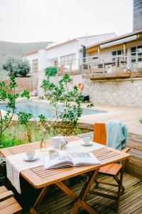 uma mesa de madeira com um livro aberto em cima em The Nest by Cooking and Nature em Alvados