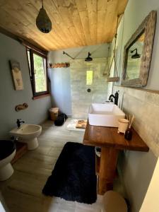 La salle de bains est pourvue d'un lavabo, de toilettes et d'une baignoire. dans l'établissement Harmony Cottage: a place for your soul., à San Felice Circeo