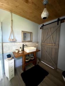 Łazienka z umywalką i drewnianymi drzwiami w obiekcie Harmony Cottage: a place for your soul. w mieście San Felice Circeo