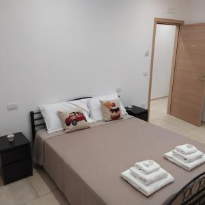 1 dormitorio con 1 cama grande y toallas. en STRADONE 132, en Gravina in Puglia