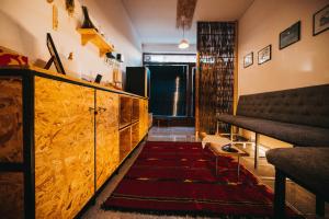 Plis Room - Old Bazaar في بيخا: غرفة معيشة مع خزانة خشبية وسجادة حمراء