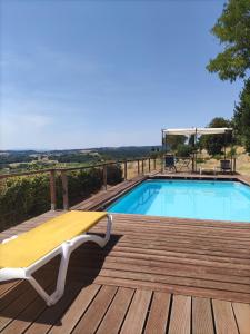 a deck with a yellow bench next to a swimming pool at La petite grande in Lurs